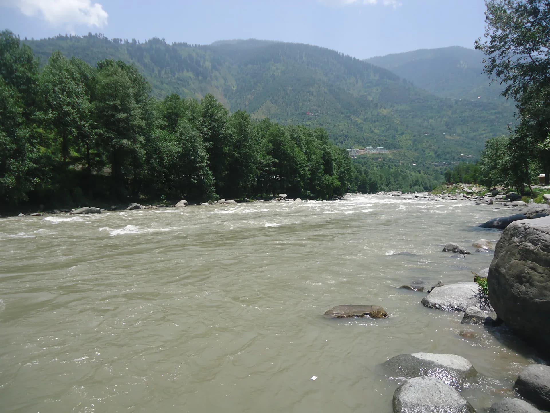 Beas River flowing past trees and hills at Kullu