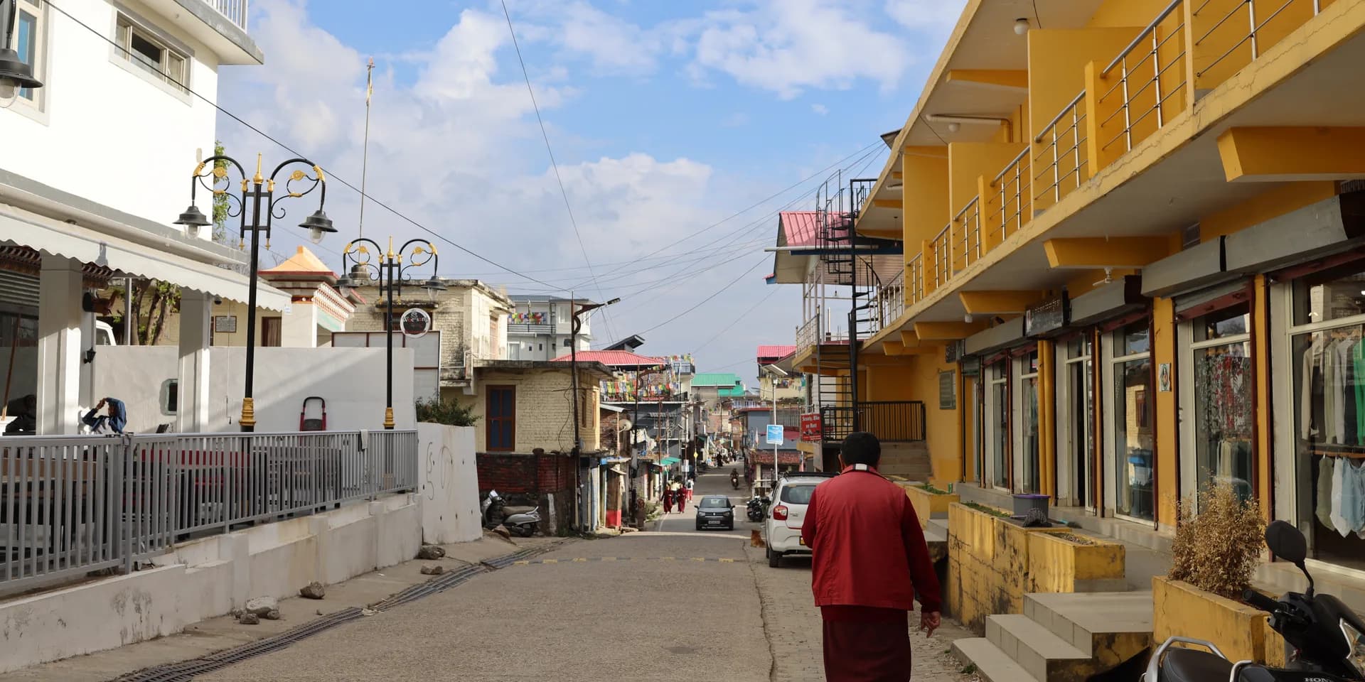 A street in Bir with shops, buildings and people walking