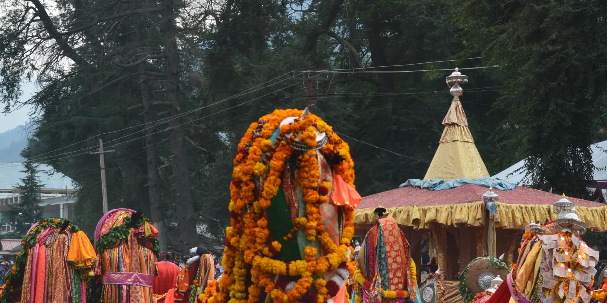 Deity palanquins and devotees beside the chariot at Kullu Dussehra