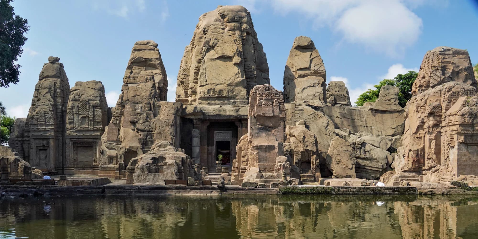 Rock-cut temple towers at Masroor reflected in the sacred pool in front of the shrines