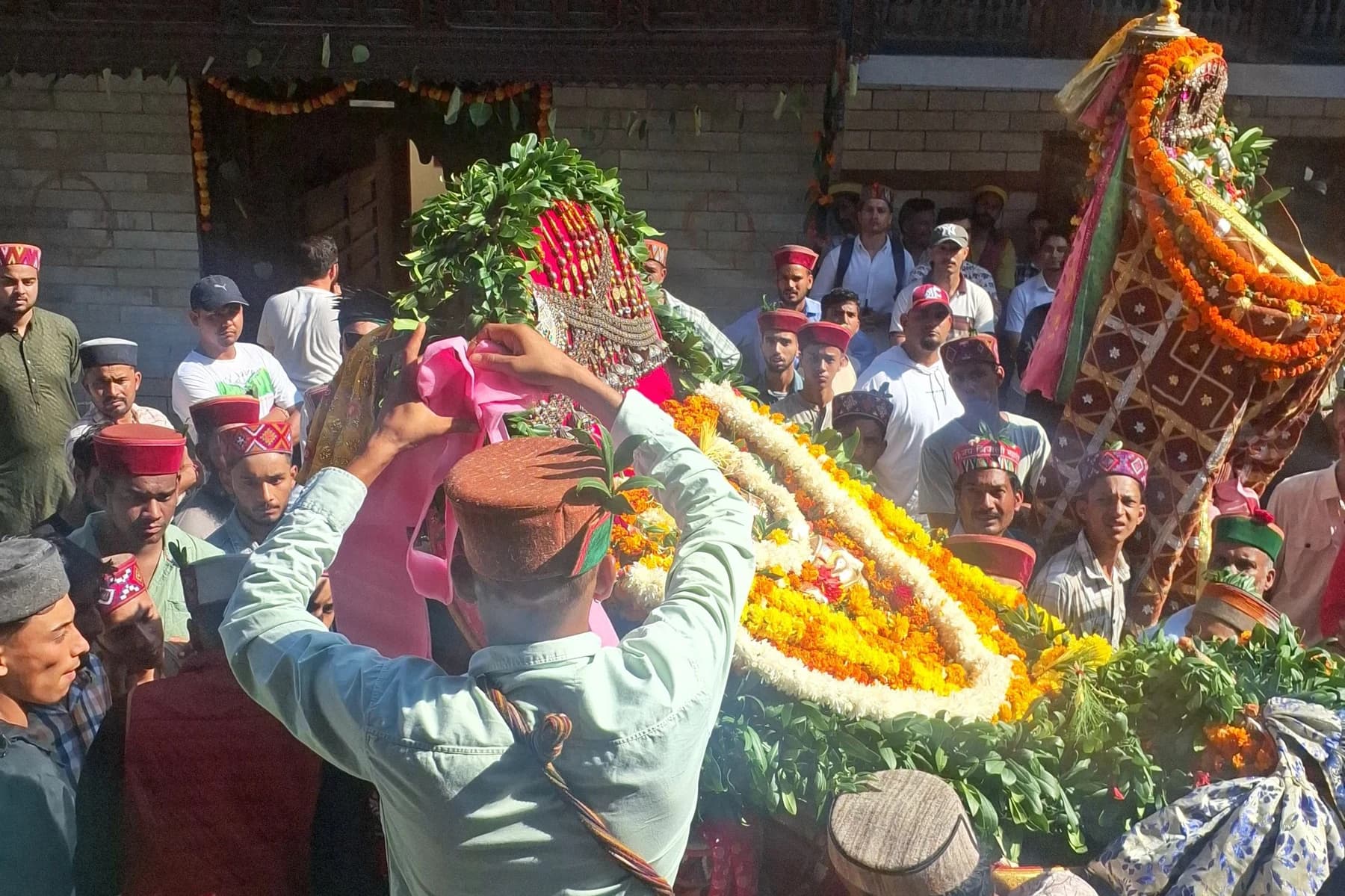 Flower-decorated deity palanquins and devotees during a Dussehra visit to Lord Raghunath in Kullu