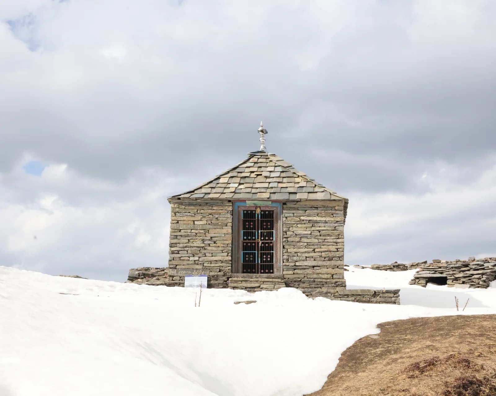 Stone shrine and snow at the Raghupur Fort site above Jalori Pass