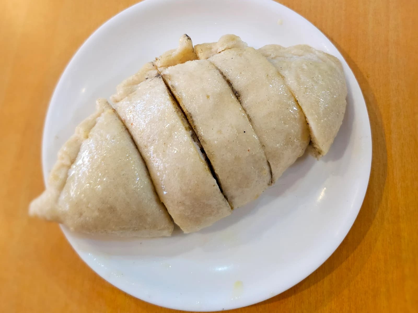 Sliced siddu on a white plate on a wooden table